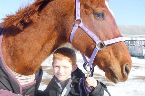 Brandon Heyman of Harrowsmith at home with Karazan, a 17-year-old mare he helped save from slaughter through NYNE